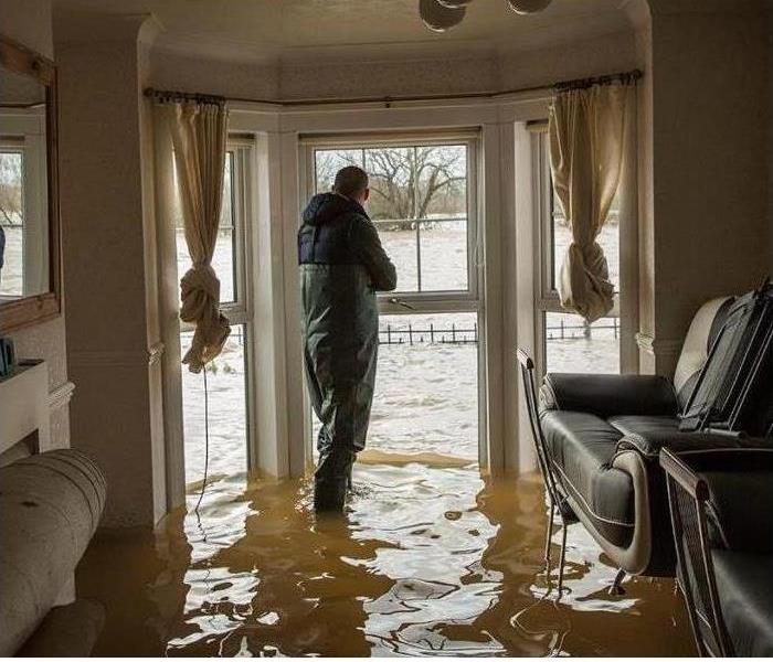 SERVPRO Estimator inspecting damage in flooded home. 